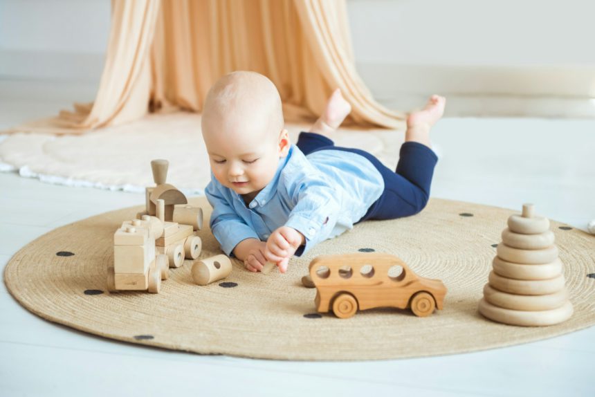 Baby playing with wooden toys. Eco-friendly wooden toys for children