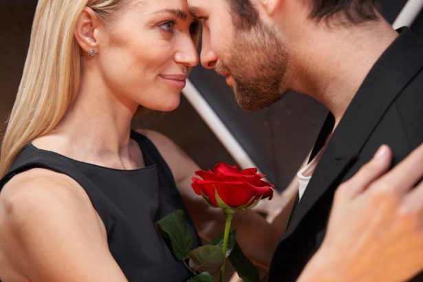 Couple is dancing with rose between them