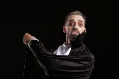 Suprised young man in dracula costume with big eyes