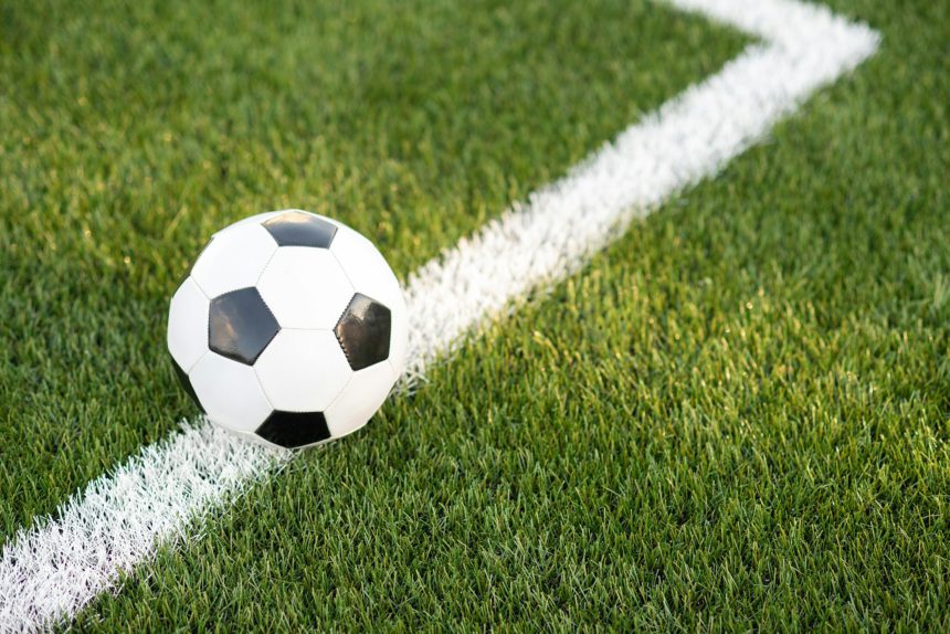 Traditional soccer ball on soccer field. black and White Soccer ball on green meadow