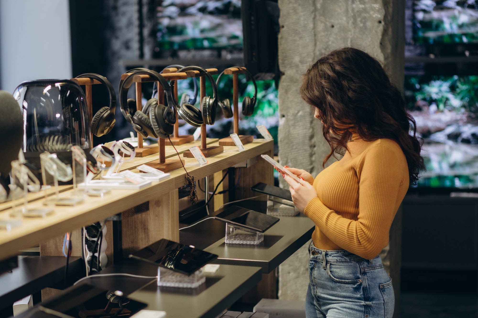 woman in an tech store chooses a tablet