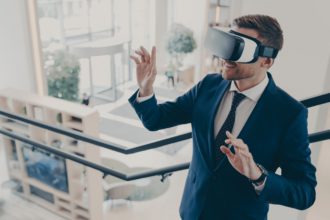 Young businessman wearing virtual reality goggles working in office